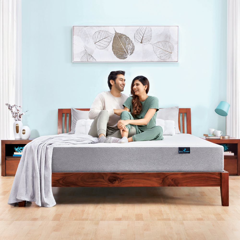 Man and women sitting on Acacia Solid Wooden Bed hero image